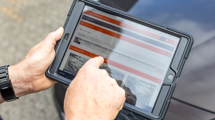 Bule på leasingbil kategoriseres på en tablet af en tekniker. 