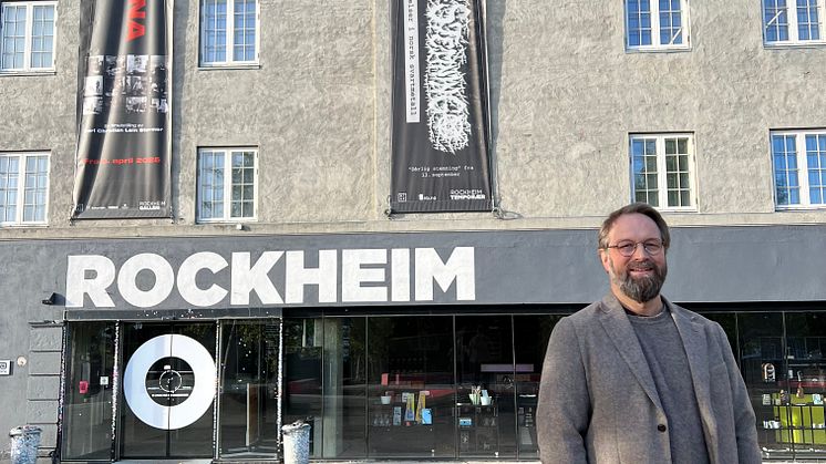 Bilde av person foran bygning med skriften Rockheim på veggen. 