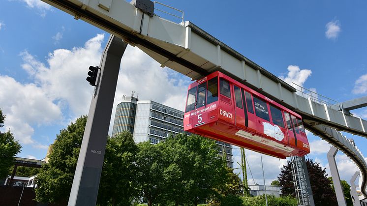 Eine H-Bahn mit roter DSW21-Beklebung