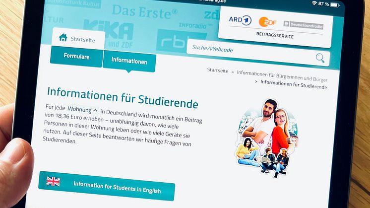 Ein Tablet zeigt Webseite des Beitragsservice mit Infos für Studierende in Deutsch und Englisch.