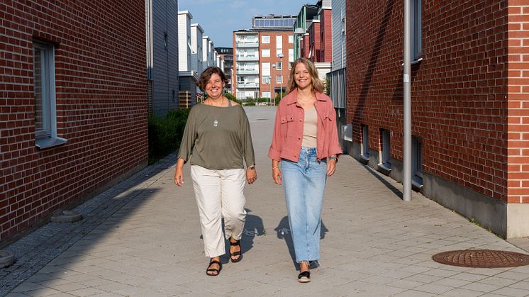 Två glad person som promenerar sida vid sida.