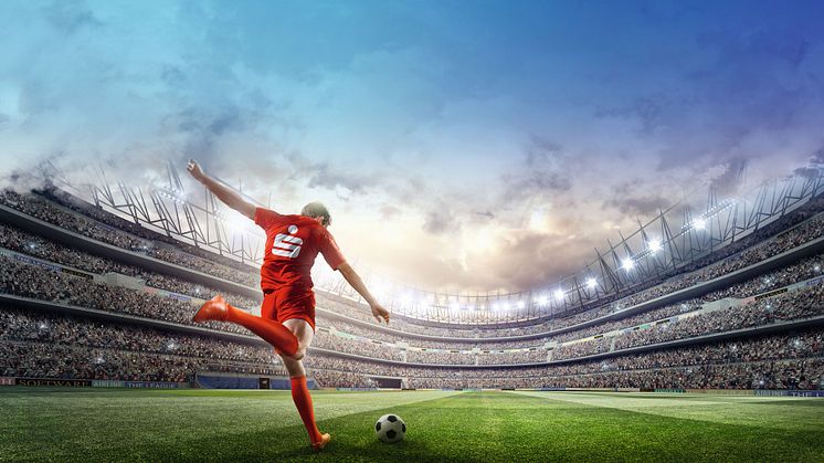 Fußballspieler im roten Trikot mit Sparkasse-Logo im großen Fußballstadion