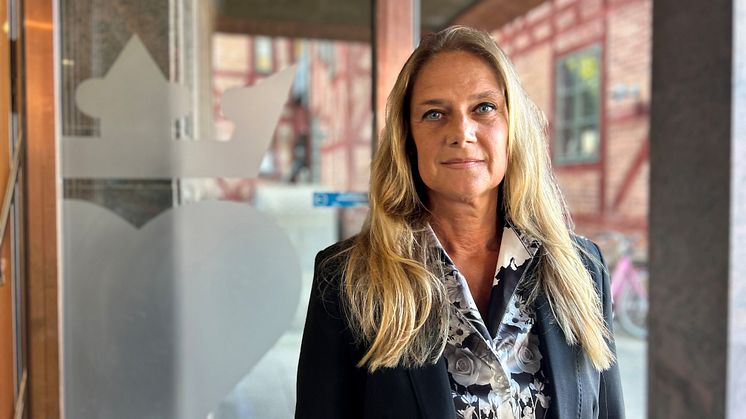 Carolina Winkler som är jurist vid Halmstads kommun står i dörren till rådhuset i Halmstad.