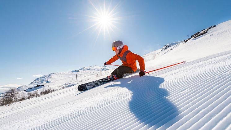 Mann står på ski ned en bratt fjellside i Hemsedal