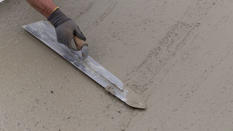 Hand som glättar betong