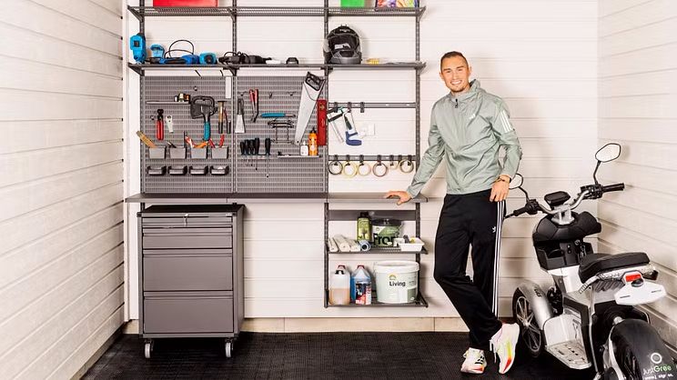 Athlete Thobias Montler standing in his organised garage with Elfa Garage+ storage, designed to hold sports equipment, tools 