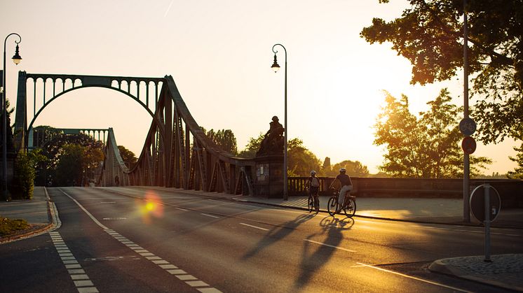 Die Glienicker brücke in Richtung Potsdam während der "Golden Hour", in orangenem Licht.