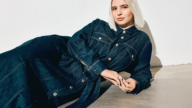 Bild på modell i jeansklänning i mörk denim från Kappahls senaste denimkollektion för hösten 2025.