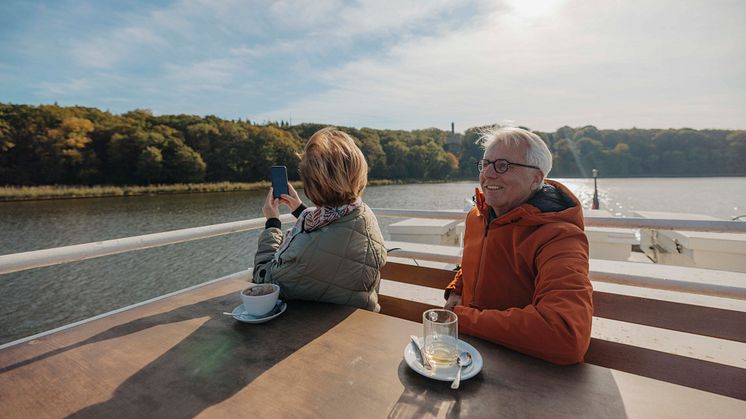 Two people are on a boat tour on the river Havel. The leaves are slowly turning golden. 