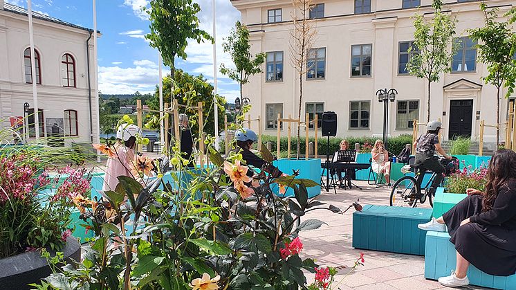 Sommartorget i Härnösand med turkosa sittkuber och vackra färgglada blomsterarrangemang. 
