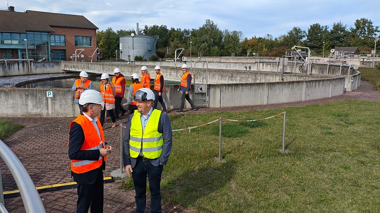 Sebastian Lösch (Veolia) führt Staatssekretär Wünsch über die Vorzeige-Kläranlage Schönebeck,beide stehen vor Belebungsbecken