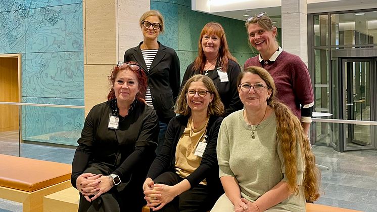 Gruppfoto av sex kvinnor som tittar in i kameran och ler.