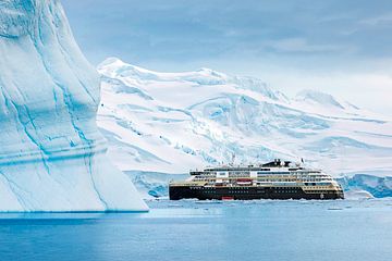 A HX ship is pictured between Antarctica, between two large icebergs in Antarctica. 