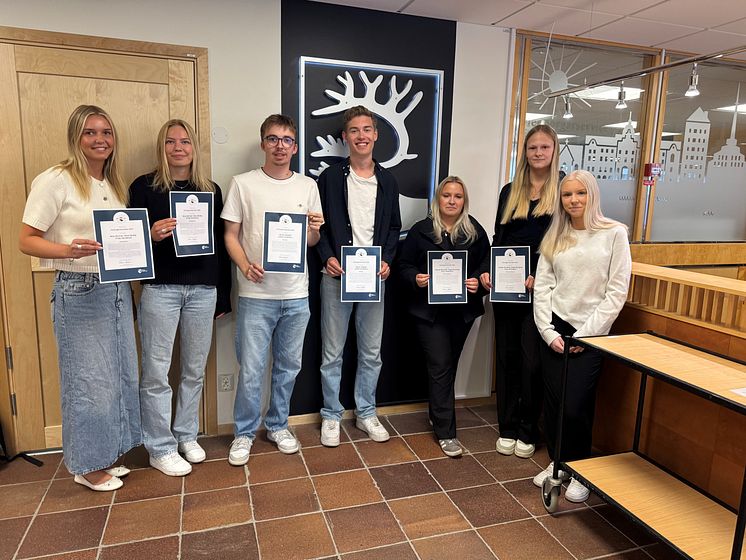 gruppbild på sju personer som håller i diplom