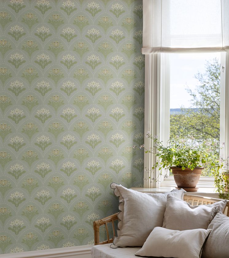 Ljusblå tapet med blommor i vardagsrum bredvid fönster