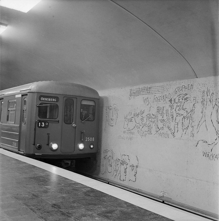Tunnelbanetåg C4 vid Östermalmstorg. Till höger Siri Derkert konst ”Ristningar i naturbetong”. Maj år 1965.