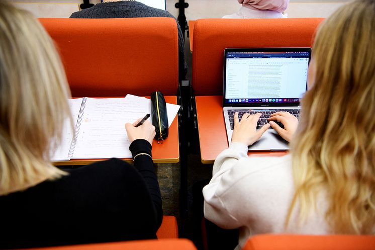 Studenter närvarar på föreläsning. Antecknar i sina datorer. 