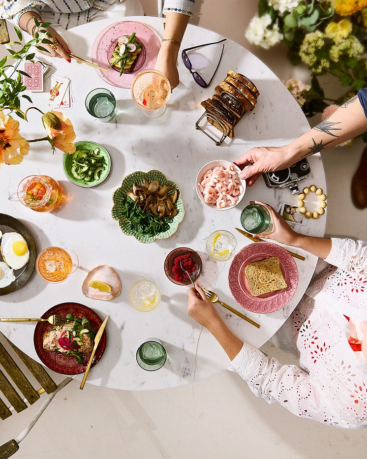 Smørrebrødsugen 2025. Bord med smørrebrød og hænder. Kartoffelmad, spejlæg, svampe, rejer og laksemad. 