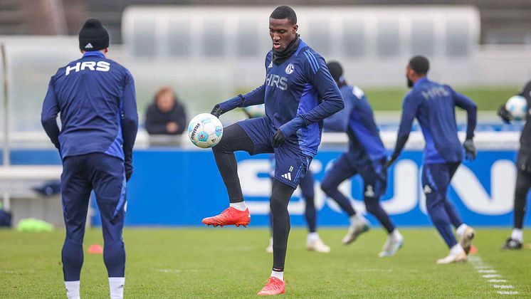 Bryan Lasme spielt den Ball im Training mit anderen Schalke-Spielern im Hintergrund 