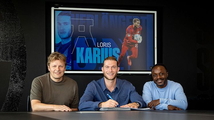 Mulder (l.) Karius (m.) Manga (r.) lachen in die Kamera, Karius unterschreibt einen Vertrag